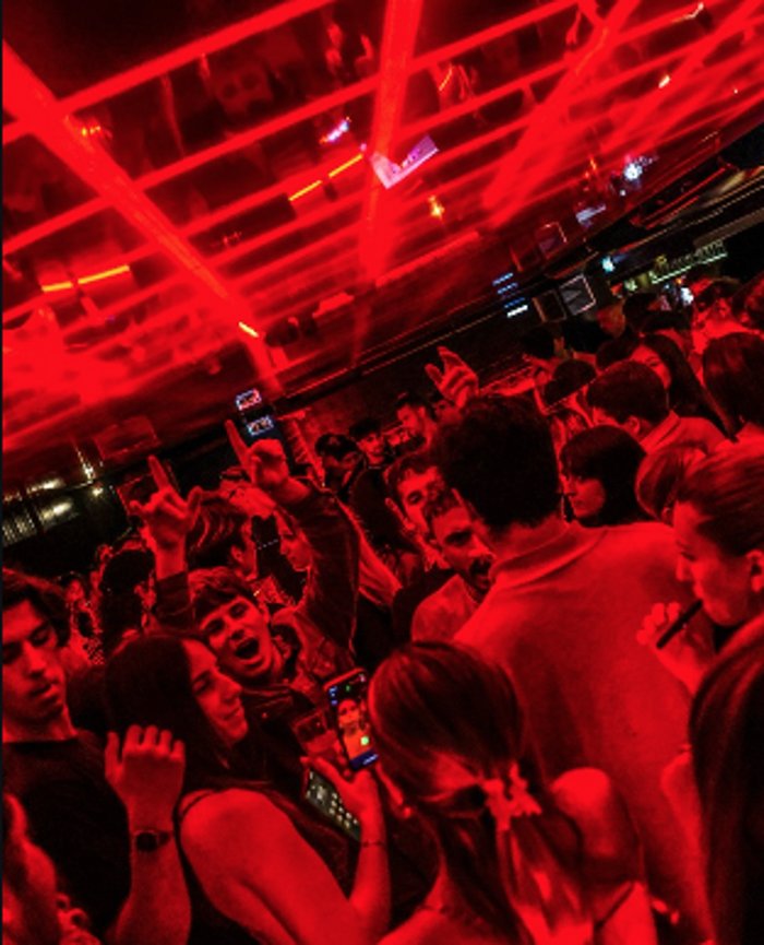 Packed dancefloor under red laser lights at MESS
